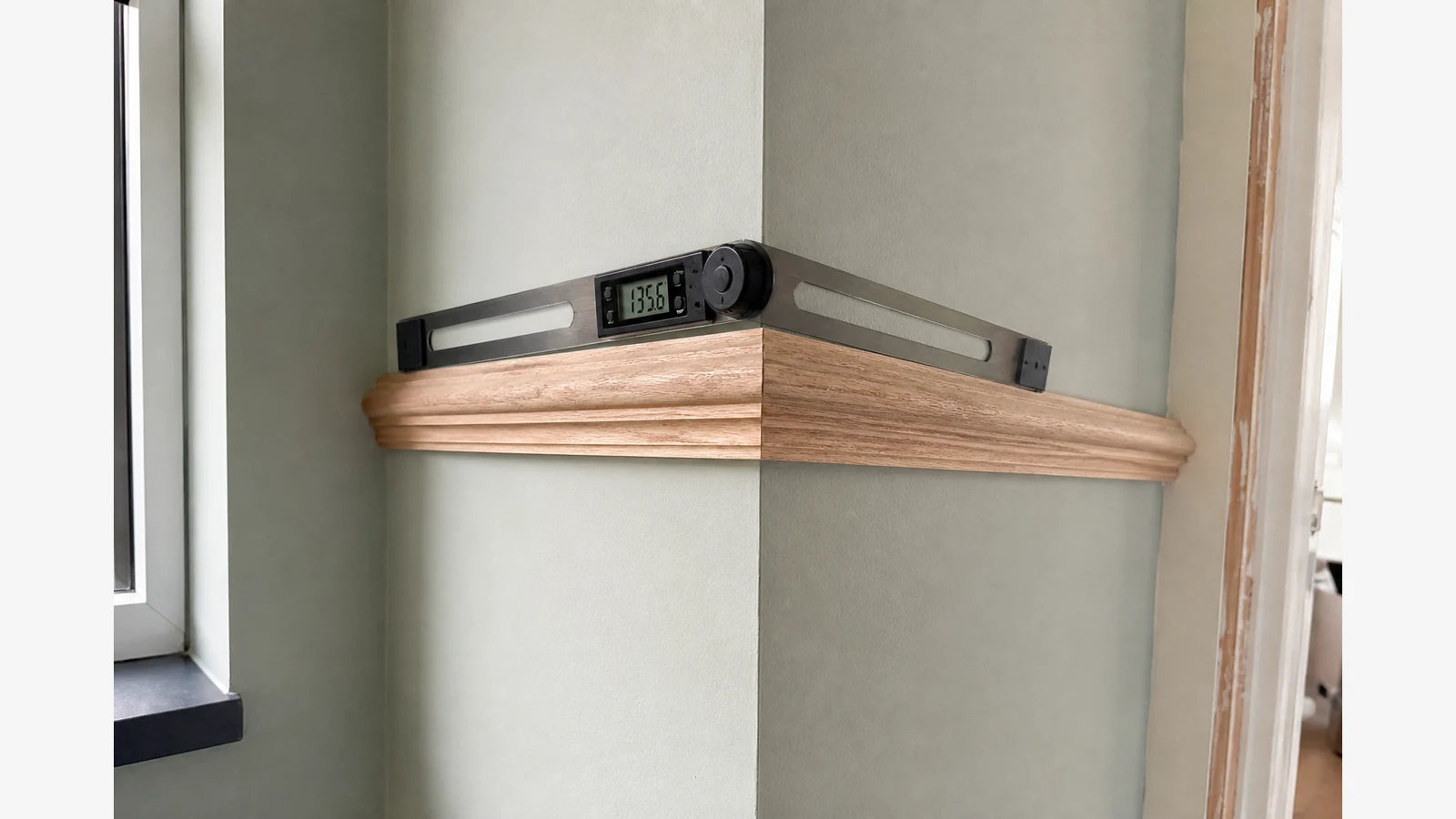 Measuring a dado rail external corner with a digital angle ruler before mitre cuts